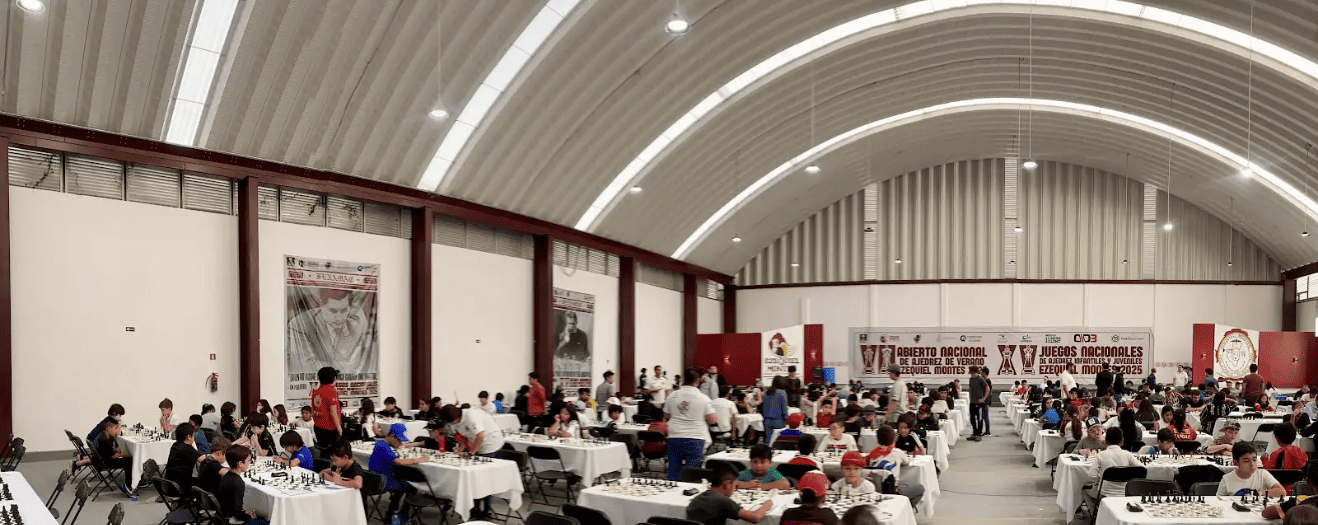 Vista panorámica del salón de juego de los Torneos de Ajedrez Ezequiel Montes 2025, con jugadores concentrados en sus partidas.